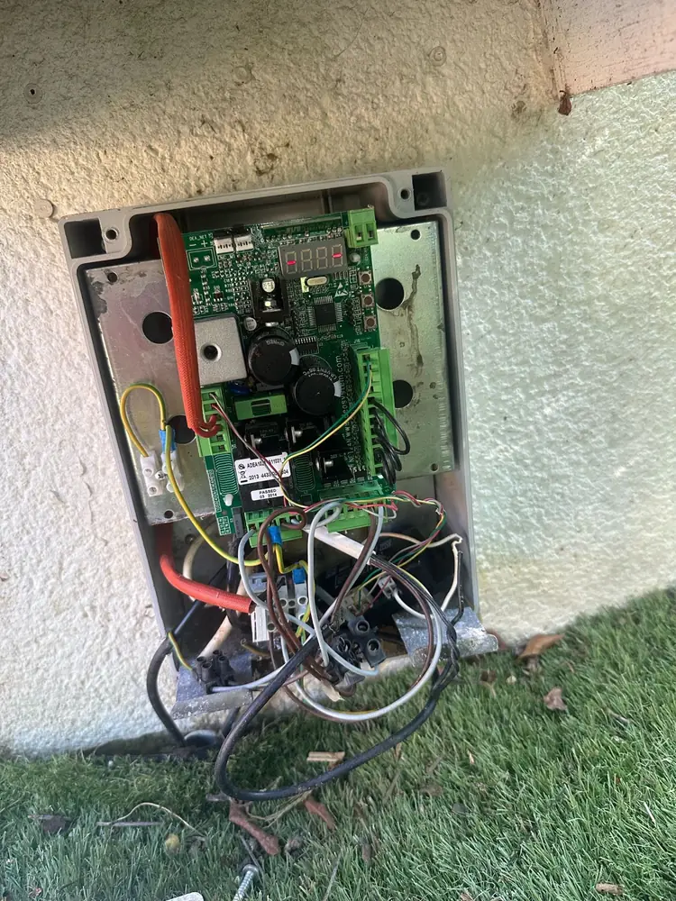 Armoire de commande d’un portail ouverte, carte électronique à contrôler