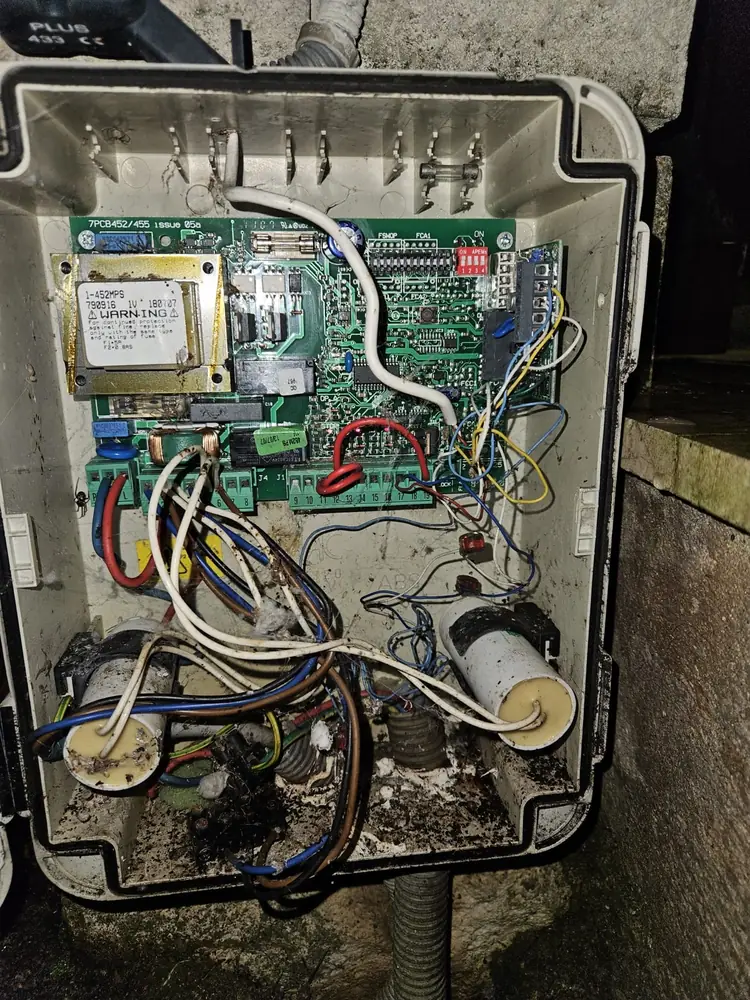 Boîtier de commande d’une porte de garage ouvert, câblage à reprendre