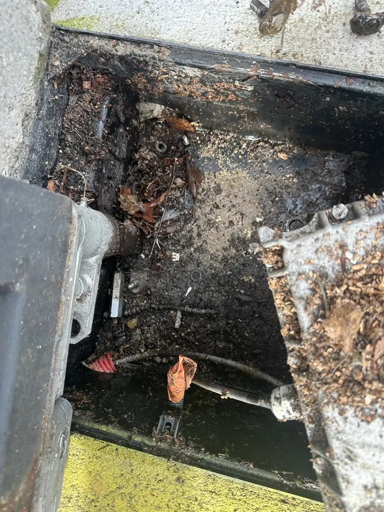 Caisson de moteur enterré rempli de débris, avant nettoyage