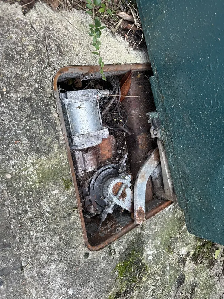Caisson de moteur enterré ouvert au pied du pilier, mécanisme à remplacer