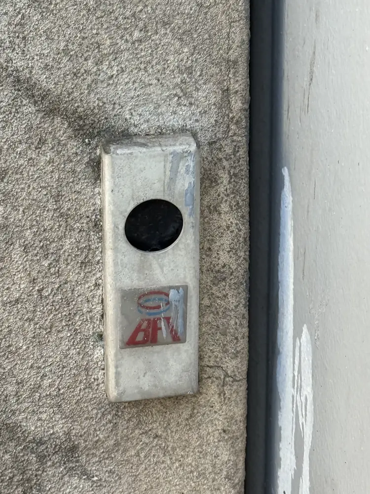 Cellule photoélectrique BFT fixée sur un mur crépi