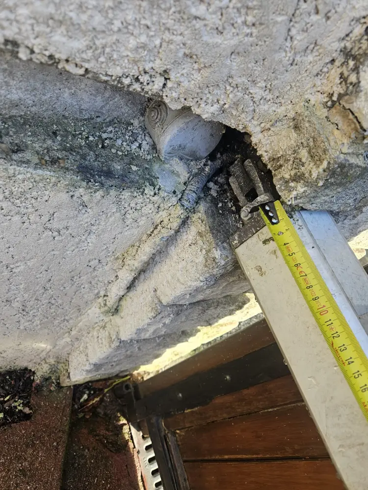Fixation d’un vérin sous l’angle d’un pilier en pierre, mètre déplié