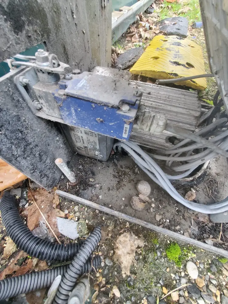 Motorisation de portail coulissant déposée, câbles débranchés