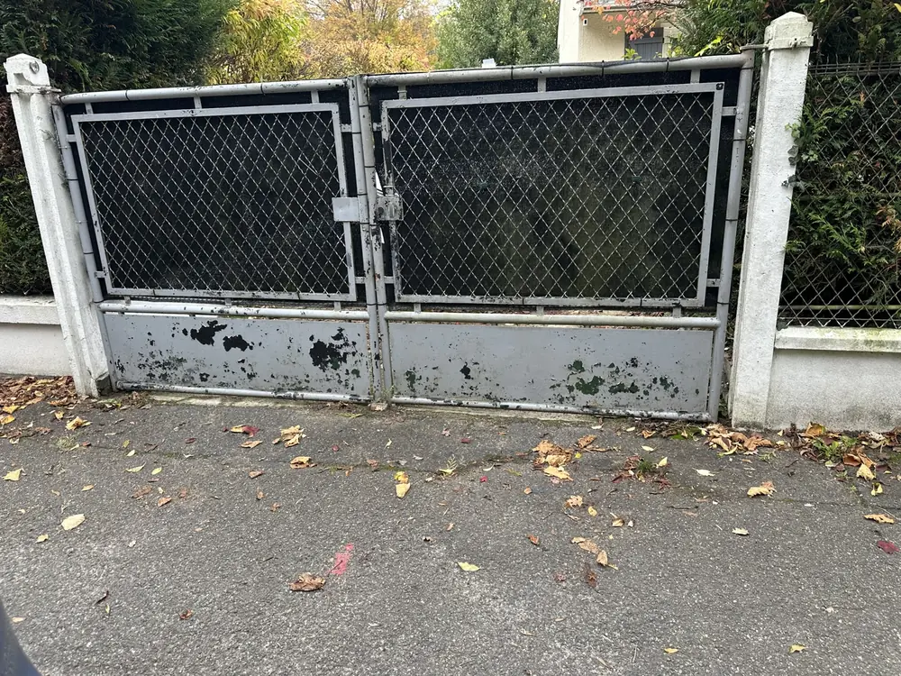 Portail battant en acier à panneaux grillagés, peinture écaillée, avant remise en état