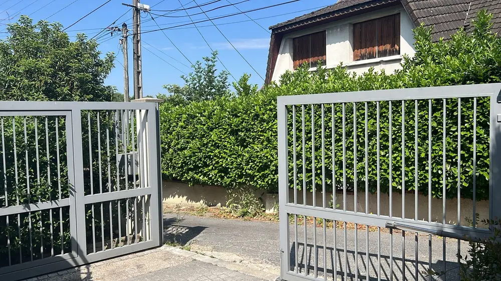 Portail battant aluminium ajouré d’un pavillon, un vantail ouvert pendant l’intervention