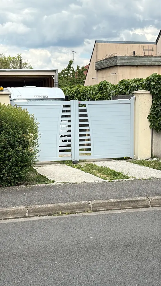 Portail coulissant aluminium blanc à lames, vu depuis la rue