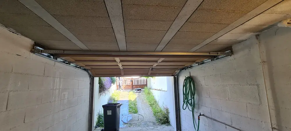 Porte de garage basculante ouverte, vue de l’intérieur du garage