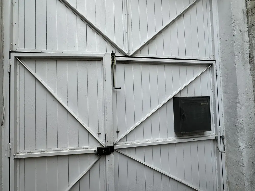 Porte de garage battante en bois blanc à croisillons