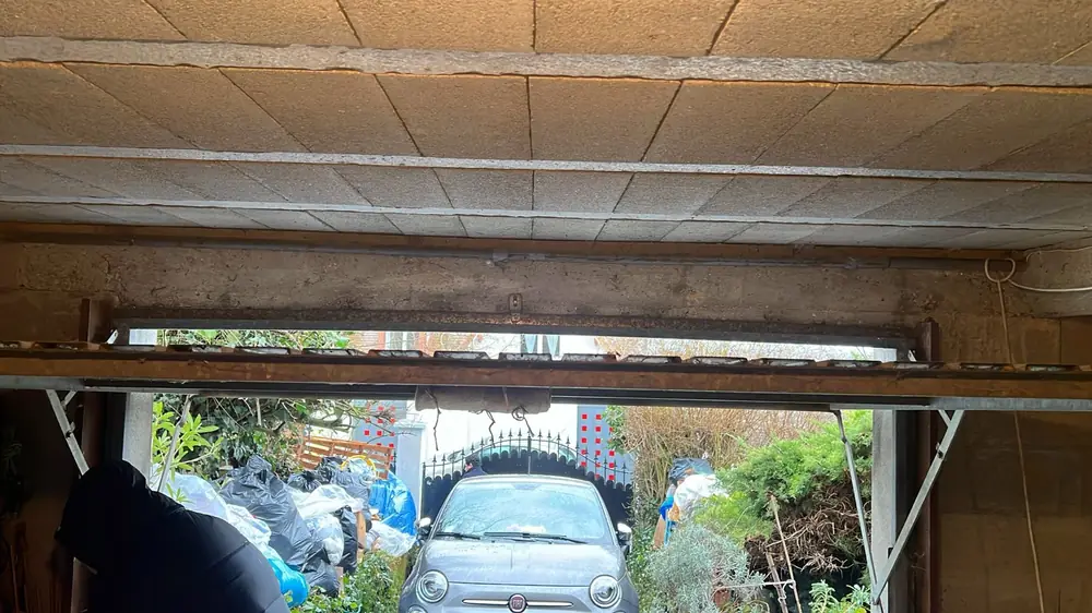 Porte de garage ouverte, linteau et rails vus de l’intérieur