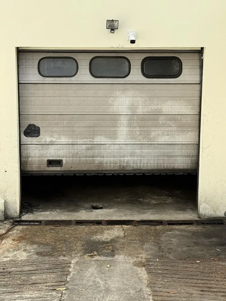 Porte de garage sectionnelle à hublots, panneaux encrassés, avant entretien