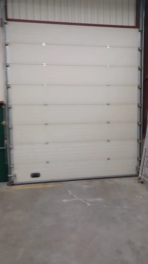 Porte sectionnelle blanche fermée, sol en béton