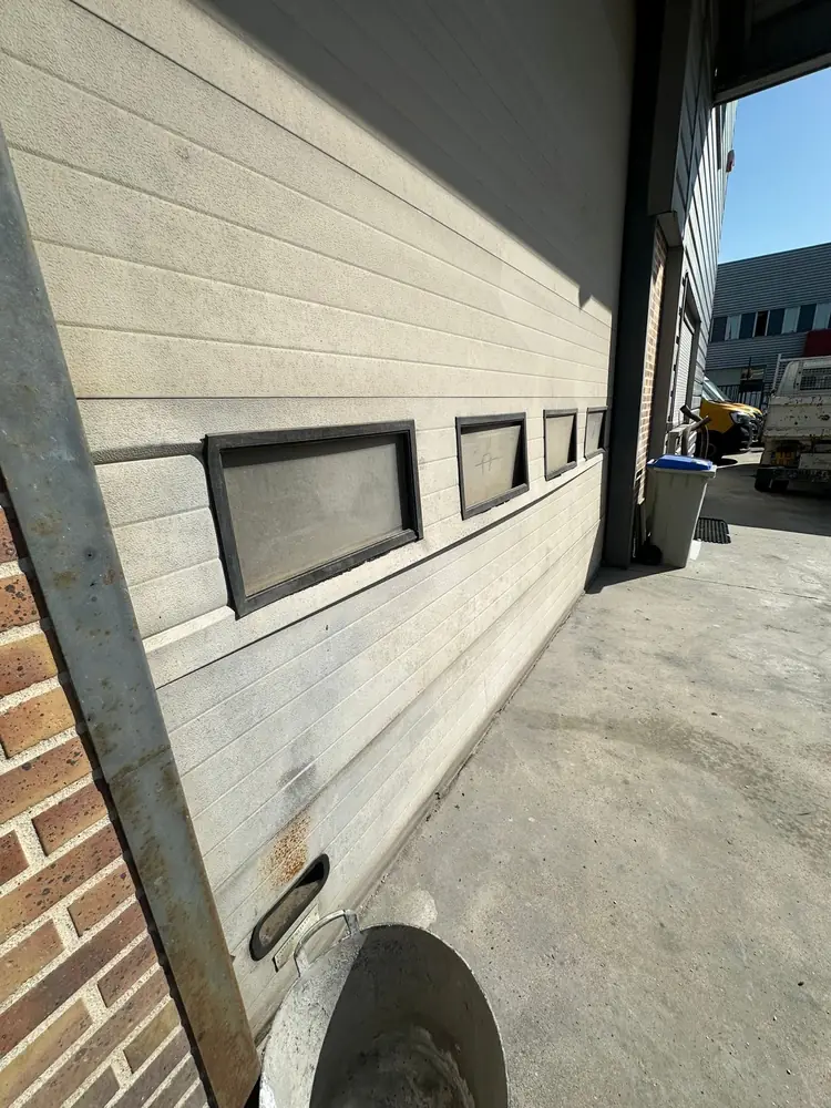 Porte sectionnelle industrielle à hublots, montant à reprendre