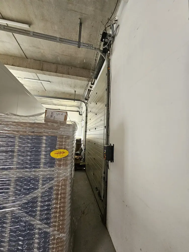 Rail de motorisation d’une porte sectionnelle industrielle, débrayage à cordon
