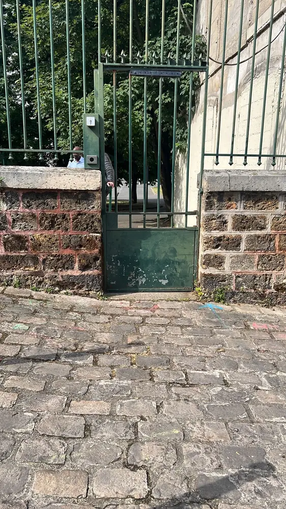 Portillon et portail en fer sur mur de meulière, entrée pavée d’une propriété