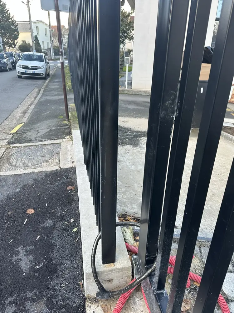 Poteau de guidage d’un portail coulissant noir : le vantail doit rester libre sur toute sa course