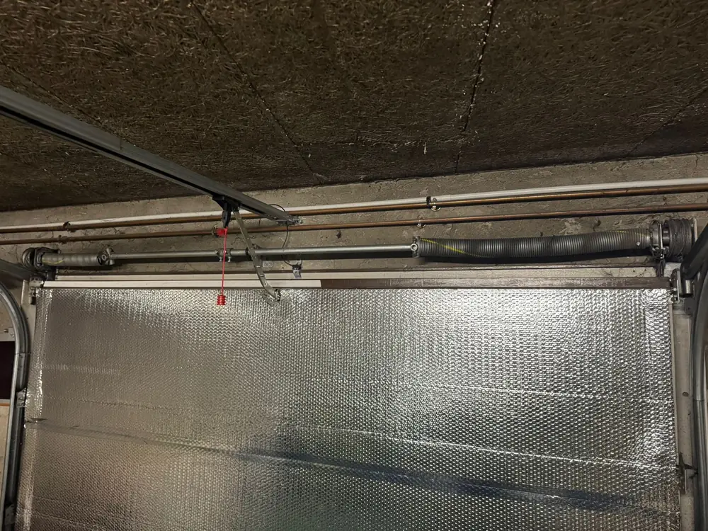 Rail et ressort d’une porte sectionnelle sous le plafond du garage