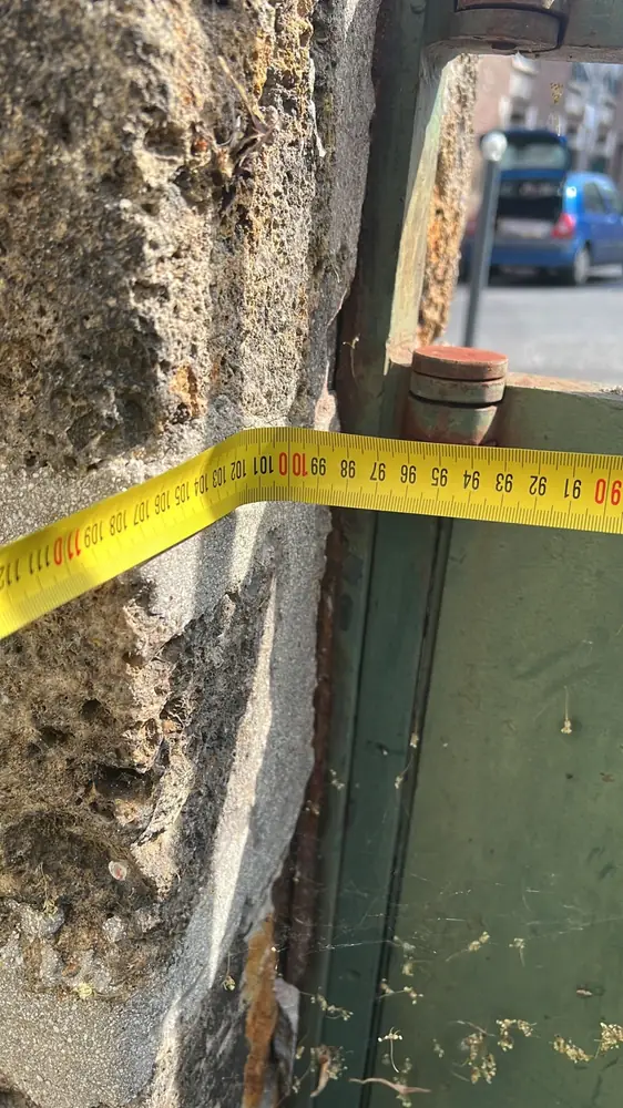 Relevé de cote d’un gond sur un pilier en pierre : l’aplomb et l’entraxe se vérifient avant de poser ou de régler une motorisation