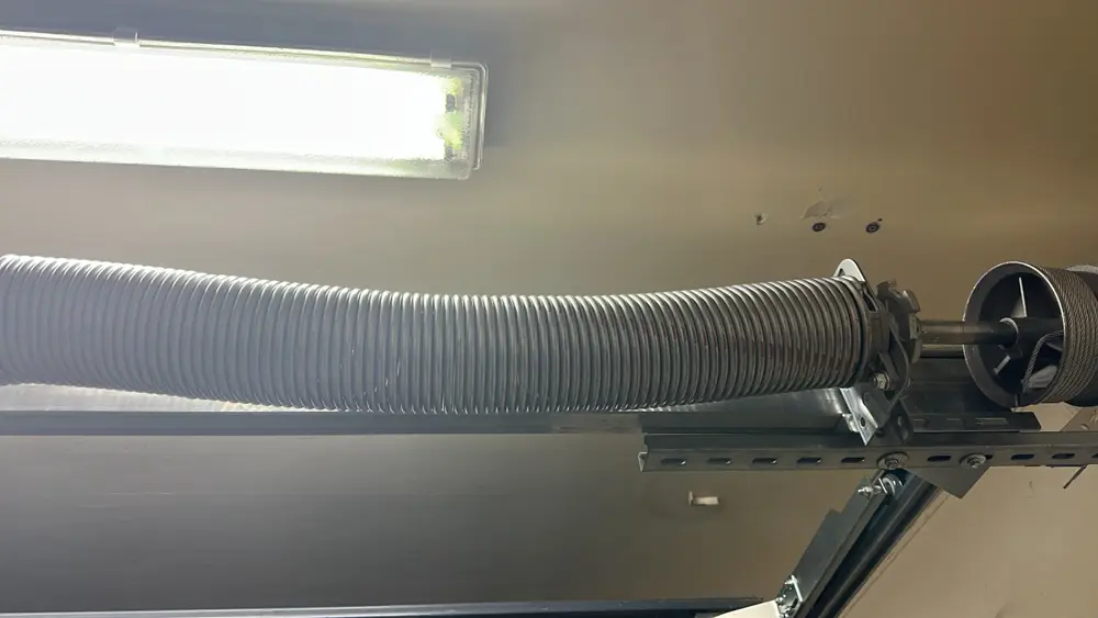 Ressort de torsion et son support au-dessus d’une porte sectionnelle