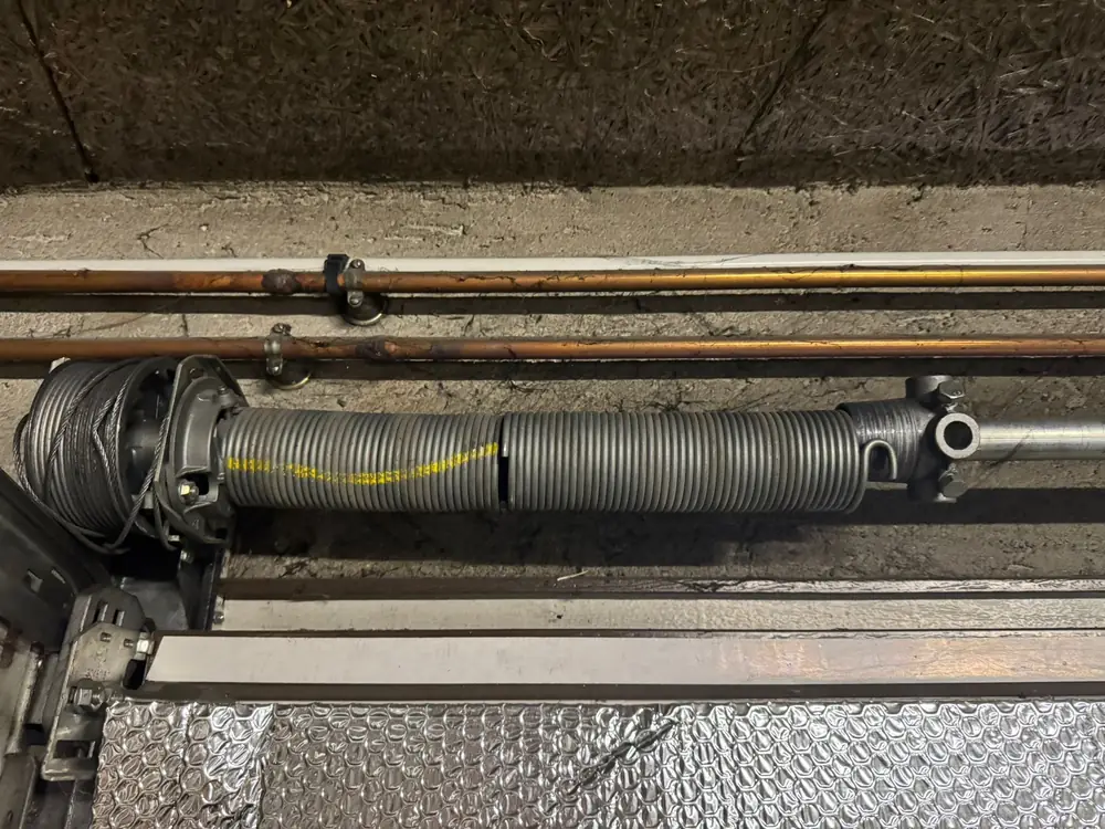Ressort de torsion et arbre d’une porte de garage sectionnelle