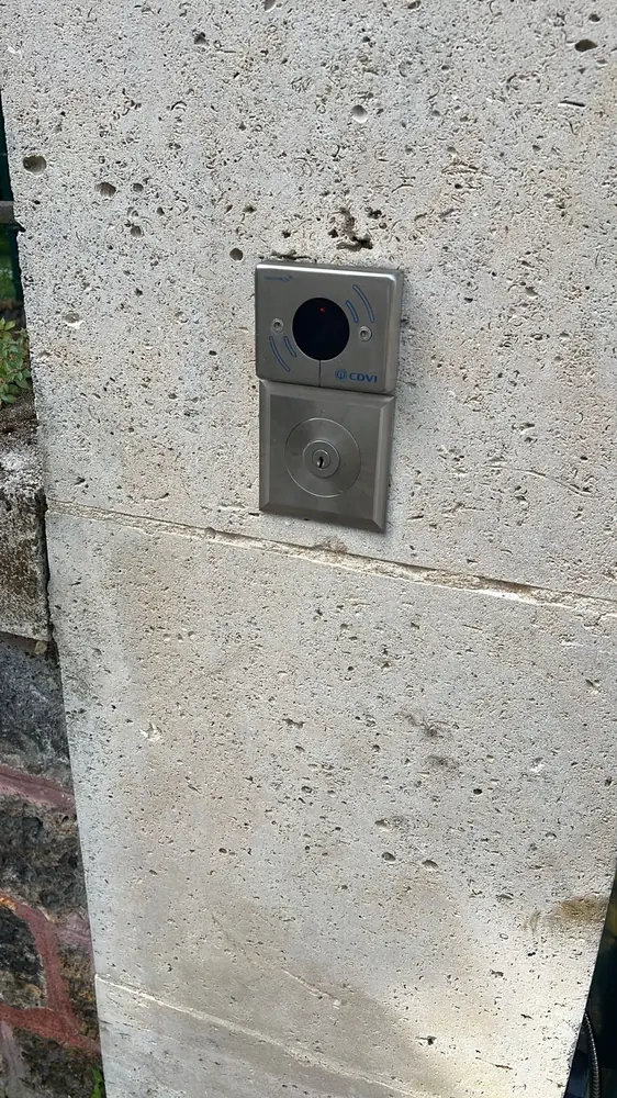 Lecteur de badge et serrure sur le pilier d’un portail d’immeuble