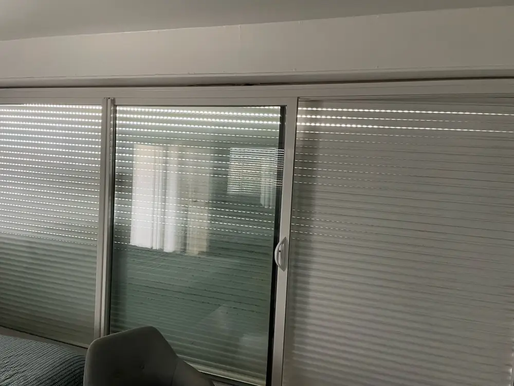 Volets roulants d’une baie vitrée vus de l’intérieur