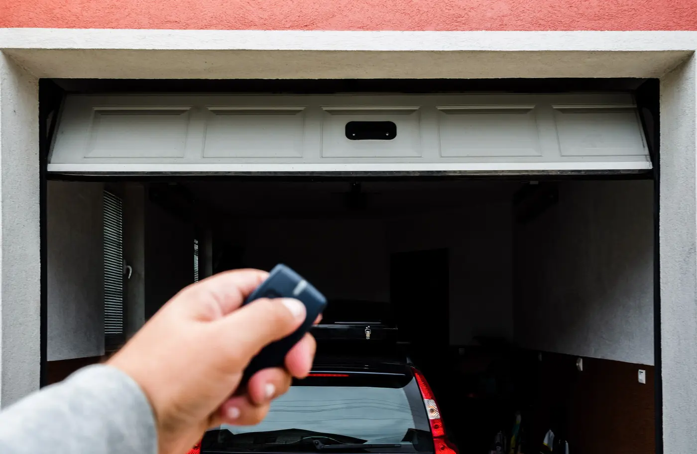 Technicien DB Fermeture devant une porte de garage